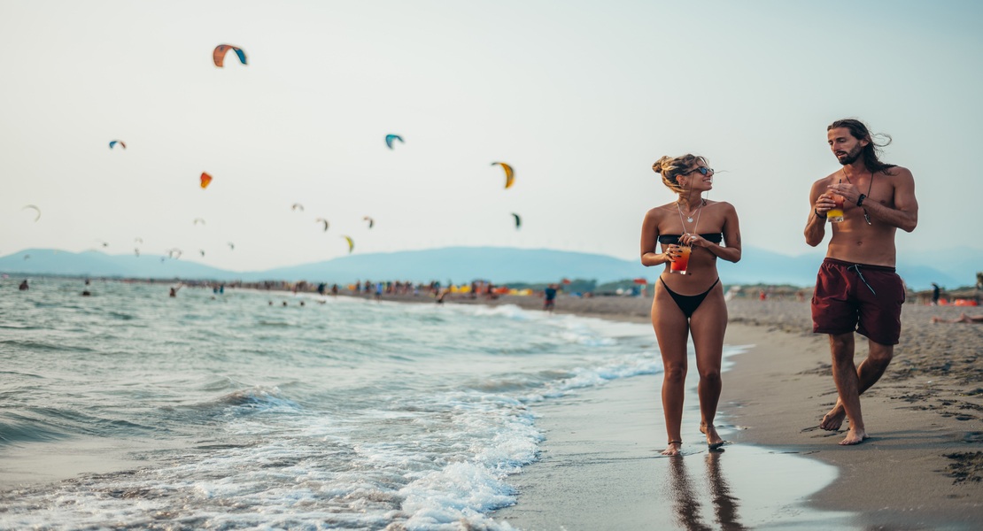 People walking along Velika Plaza beach in Ulcinj, Montenegro
