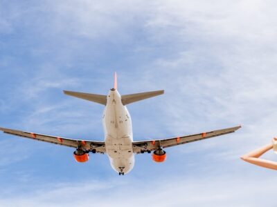 Woman watching an airplane flying above at Montenegro airport