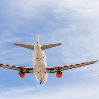 Woman watching an airplane flying above at Montenegro airport