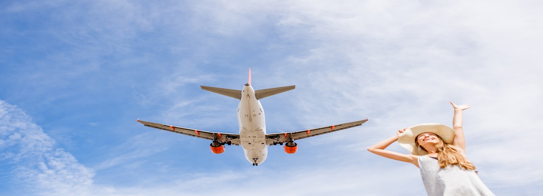 Woman watching an airplane flying above at Montenegro airport
